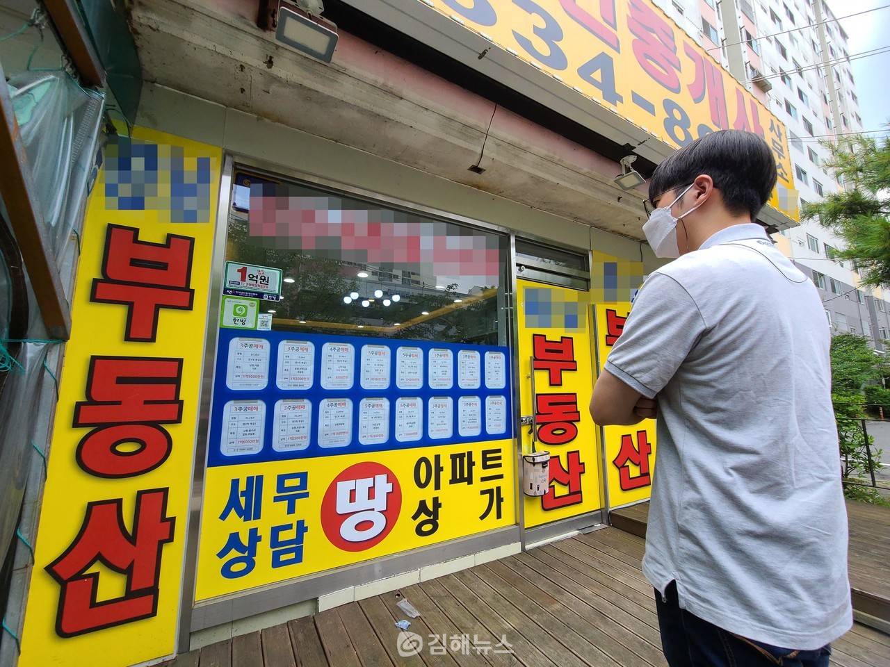 김해시민 남모(27) 씨가 김해 구산동 한 부동산 앞에서 아파트 정보를 보고 있다. 최인락 기자