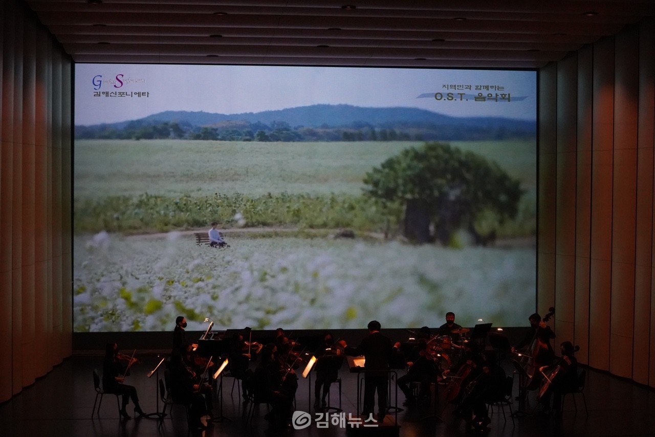 지역민과 함께하는 O.S.T. 음악회에서 김해신포니에타가 영화의 한 장면을 배경으로 연주를 하고 있다.  사진제공 = 김해신포니에타