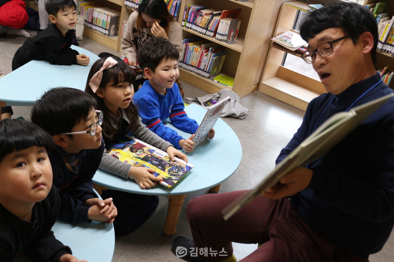 동화구연 자원봉사 선생님이 아이들에게 그림책을 읽어주고 있다.