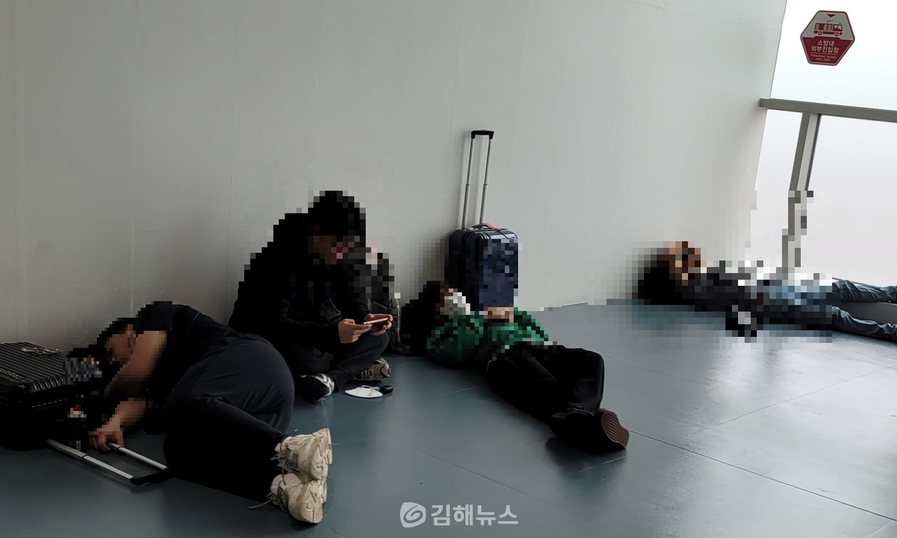 일부 탑승객들이 10시간 탑승지연 통보를 받자 출국장 구석에서 누워서 자고 있다. (사진=독자제공)
