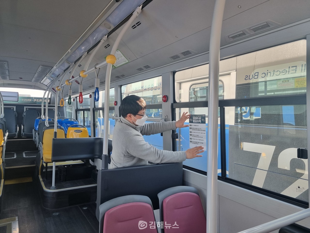 김해시 한 공무원이 버스에 방역수칙 준수 안내문을 부착하고 있다. (사진=김해시)