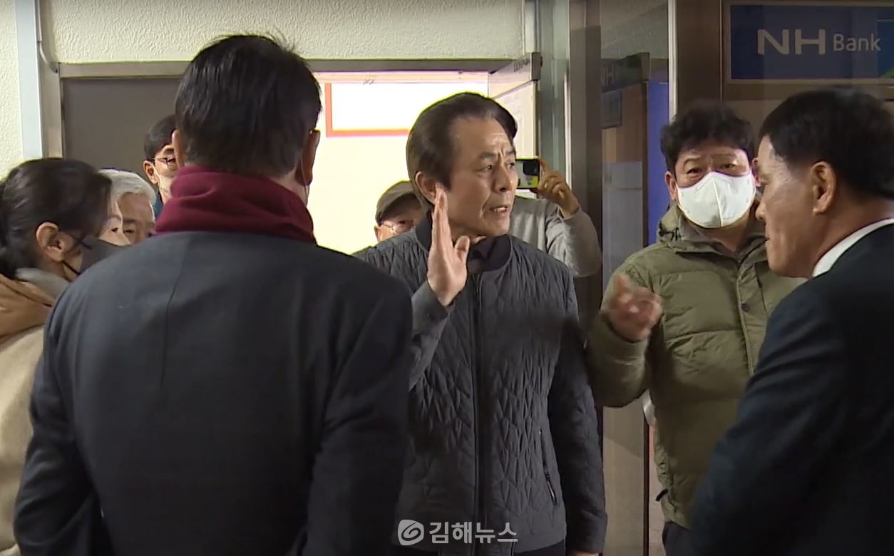 김해시청 프레스센터 입구를 막아선 일부 당원들과 이야기하고 있는 박병영 도의원(오른쪽). 